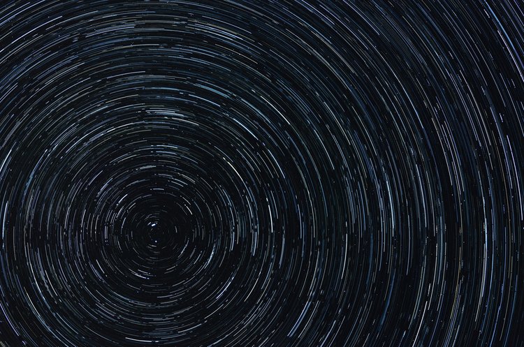 Hatha Yoga e Ritmo Naturale – Star Trail con Scie Stellari Star trail notturno con scie circolari delle stelle concentriche su cielo notturno scuro