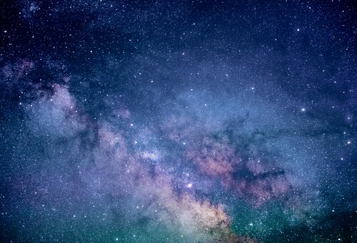 Cielo notturno stellato con la Via Lattea, sfumature di blu e viola con nubi di polvere cosmica
